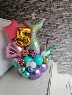 the number five balloon arrangement is decorated with mermaid tail, starfish, and seashells