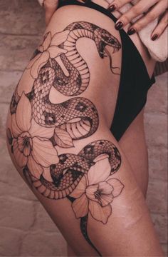 a woman with a snake tattoo on her thigh