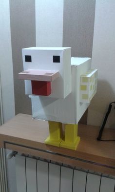 a paper mache chicken standing on top of a wooden table next to a radiator