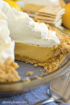 a slice of lemon pie with whipped cream on top is sitting in a glass bowl