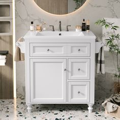 a white bathroom vanity with a round mirror above it and plants on the counter top