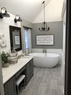 a bathroom with a tub, sink and large mirror in the middle of it's wall