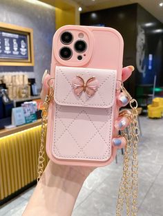 a person holding up a pink cell phone case with a butterfly on it's back