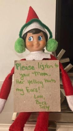 an elf is holding a sign that says please listen to your mom, he's really