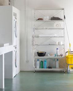 a room that has some shelves with various items on it and a washing machine in the corner