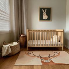 a baby's room with a deer rug and crib