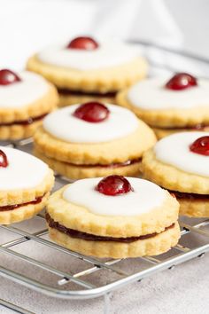 small cookies with cherries and cream filling on a cooling rack