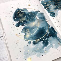 an open book with watercolors and gold foil on it, featuring the silhouette of a bear