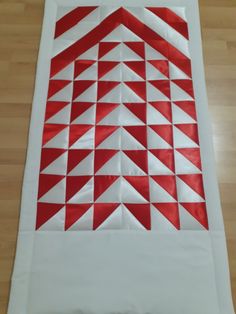 a red and white piece of paper on top of a wooden floor