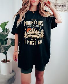 "Get ready for your next hiking adventure with this stylish \"The Mountains are calling\" t-shirt! Whether you're a seasoned mountaineer or simply love to hit the trails, this shirt is the perfect way to show off your passion for the great outdoors. Featuring a professionally printed design, this shirt is sure to turn heads on the trail. The comfortable relaxed fit makes it easy to move in, while the 100% cotton construction (except for heather colors, which feature a cotton-poly blend) ensures that it will hold up to even the toughest outdoor conditions. Available in a range of unisex sizes, this shirt is designed to fit a variety of body types. Be sure to check the size chart in the images to find the perfect fit for you. So why wait? Order your \"The Mountains are calling\" t-shirt toda Hiking Tshirt, Mountains Are Calling, Hiking Adventure, The Mountains Are Calling, Mountain Climbing, Comfort Colors Tee, Trendy Tee, Travel Shirts, Move In