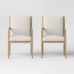 two beige chairs with arms and legs, facing each other