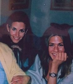 two women sitting next to each other smiling