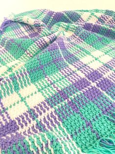 a green and purple blanket sitting on top of a table