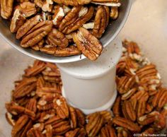 pecans are in a bowl on top of a cup