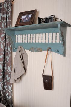 a blue shelf with a camera and purse hanging on it