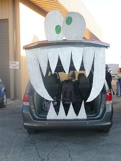 the back end of a car with an open trunk and large white monster's mouth