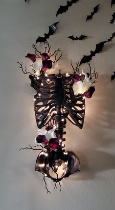 a skeleton with flowers and bats on it's back is mounted to the wall