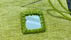 a green piece of yarn with a mirror on it