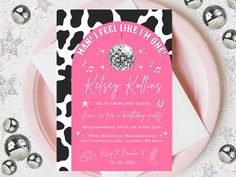 a pink and black party card on top of a plate with silver confetti