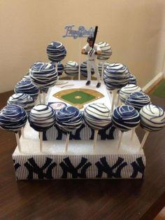 a baseball themed cake with blue and white cupcakes on the base, in front of a batter's box