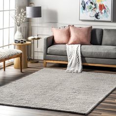 a living room with a gray couch and wooden flooring