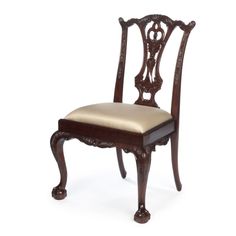 an antique wooden chair with beige upholstered seat and back cushion on white background