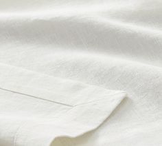 close up view of white linen material with small stitching on the chest and shoulder