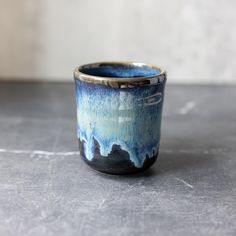 a blue and black cup sitting on top of a table