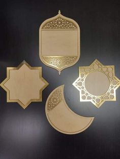 three mirrors and two plaques on a black surface with gold trimmings, one in the shape of a crescent