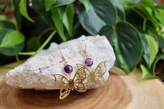 These beautiful dangle earrings feature 8mm gold plated hydro amethyst connectors and 25x33x brass butterfly charms. All connected to gold plated stainless steel earring hooks. Amethyst, known for its calming properties, brings a sense of tranquility. Paired with the butterfly, a symbol of transformation and rebirth, these earrings carry a meaningful message of personal growth and positive change. These earrings would be a thoughtful gift for someone with a February Birthday as amethyst is the b Purple Butterfly Charm Earrings For Gift, Purple Brass Earrings As Gift, Gold Metal Earrings With Butterfly Charm, Gold Earrings With Butterfly Charm, Handmade Amethyst Gold Earrings, Gold Amethyst Earrings With Ear Wire, Handmade Gold Amethyst Earrings, Handmade Gold Butterfly Earrings, Gold Butterfly Earrings