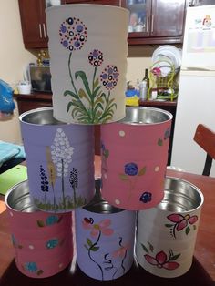 there are many tin cans that have flowers painted on them