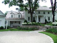 a large white house sitting next to a lush green field