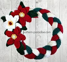 two crocheted wreaths with flowers on them, one is red and the other is white