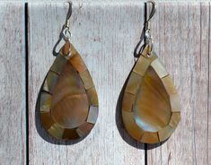 These beautiful earrings feature cross- cut sections of Brown Mother of Pearl (Flat Lip Oyster) in a Teardrop shape. The iridescence of these Mother of Pearl is really amazing. Depending on the angle of the light source they will radiate colors from Browns to Pinks. The shells are then polished to a high gloss to reveal the beauty of their natural pattern. DETAIL - Shell types :Brown Mother of Pearl Shell - Material: Sterling Silver Ear Wire and Jump Ring - Backside of earrings bonded with black Teardrop Fish Hook Earrings Gift, Brown Teardrop Earrings For The Beach, Brown Teardrop Earrings For Beach, Handmade Teardrop Earrings For Beach, Shell Types, Jewelry Island, Island Jewelry, Hawaiian Jewelry, Beach Earrings