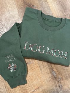 Our personalized green dog mom floral sweatshirt is a delightful and comfortable piece of clothing that combines floral aesthetics with a dog-loving identity. Stay cozy and stylish while showing love for your pets. Personalize the sleeve with the names of your pets. Up to two names only, additional names will be $5 extra. 50% cotton, 50% polyester 1×1 ribbed collar, cuffs, and waistband with spandex Double-needle stitching throughout Pill-resistant air jet yarn Set-in sleeves Please specify your preferences for color and font. This sweatshirt is green, with the design as shown in the picture Since these are personalized products we can't accept returns. Remember our processing time is from 3-5 business days. If no personalization preferences are provided, we will personalize with the color Dog Mom Embroidered Sweatshirt, Green Cotton Sweatshirt With Custom Print, Floral Aesthetics, Showing Love, Floral Sweatshirt, Dog Mom Sweatshirt, Dog Mama, Mama Sweatshirt, Mom Sweatshirt