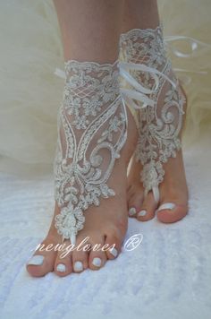 the bride's barefoot sandals are adorned with white lace