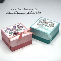 two small boxes with butterflies on them sitting next to each other