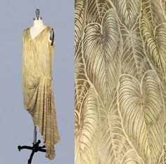 "Incredible 1920s metallic lame dress in a leaf motif. Dense, shimmering, metal fibers. Photos do not capture the beauty of this piece; the way it reflects and catches the light is amazing. Bright golden threads. Loose and easy fit. Asymmetrical, faux wrap silhouette, with v neck, perfect draping from pleated hip swag, and trailing hem. Attached sheer silk camisole lines the bodice. LAYAWAY is available for all items, please message me for details. Measurements: *no closures, slips over the head Recommended for a size S-M Bust: 35\" Dropped waist: 36\" Length: 45\" , 59\" Condition:  Great. Upon close inspection, I found one seam mend to shoulder, A few holes at hem of train, Some small faint spots of discoloration mostly at hip pleating. Also several pinhead sized spots wear fabric shows 20s Gown, Lamé Dress, Art Deco Clothing, 1920 Dress, 20s Dresses, Lame Dress, Art Deco Dress, Golden Dress, Leaf Motif