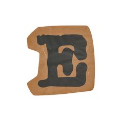 the letter e is made out of brown paper and has black letters on it,