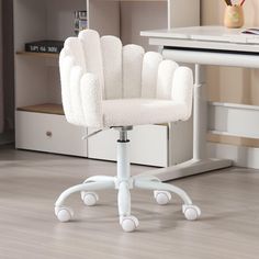 a white office chair sitting on top of a hard wood floor next to a desk