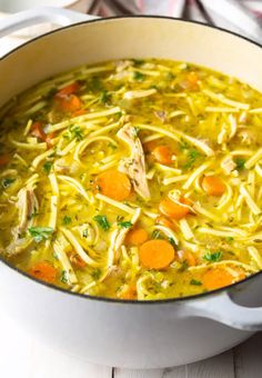 a pot filled with chicken noodle soup on top of a table