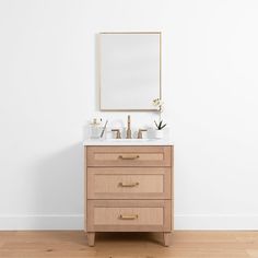 a bathroom vanity with two sinks and a large mirror above it on a white wall