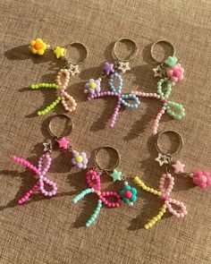 six pairs of beaded keychains are arranged in the shape of an x