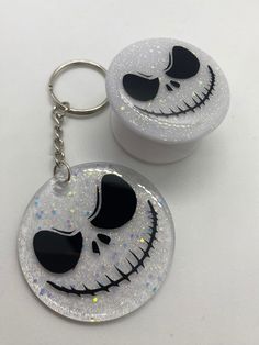 two white and black jack skellingy faces are on the same keychain