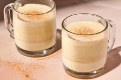 two mugs filled with liquid sitting on top of a table