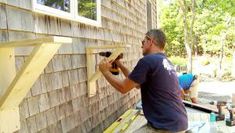 a man is working on the side of a house with some tools in his hands