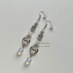 "Handmade Beaded Earrings ✿ Made with glass beads, glass crystal beads, and metal accents ✿ Silver, milky white, and iridescent clear ✿ The earrings are 2.6\" long (3.25\" total) Fish Hook Options ✿ The Titanium fish hook is hypoallergenic and ideal for sensitive skin ✿ The regular fish hook is made of nickel free metal, it is not hypoallergenic" Adjustable Nickel-free White Crystal Earrings, Nickel-free White Crystal Metal Earrings, Nickel-free White Metal Crystal Earrings, White Metal Dangle Crystal Earrings, White Heart Beads Drop Earrings, White Heart Beaded Dangle Earrings, White Metal Dangle Beaded Earrings, White Beaded Czech Glass Earrings, White Czech Glass Beaded Dangle Earrings