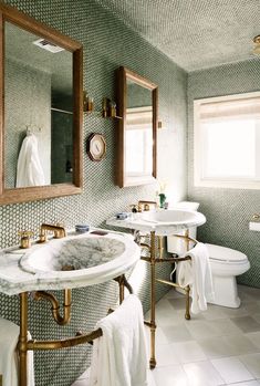 a bathroom with two sinks and mirrors in it