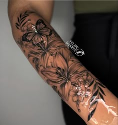 a woman's arm with flowers and butterflies on it