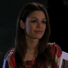 a woman with long hair wearing a red and white striped shirt looking at the camera